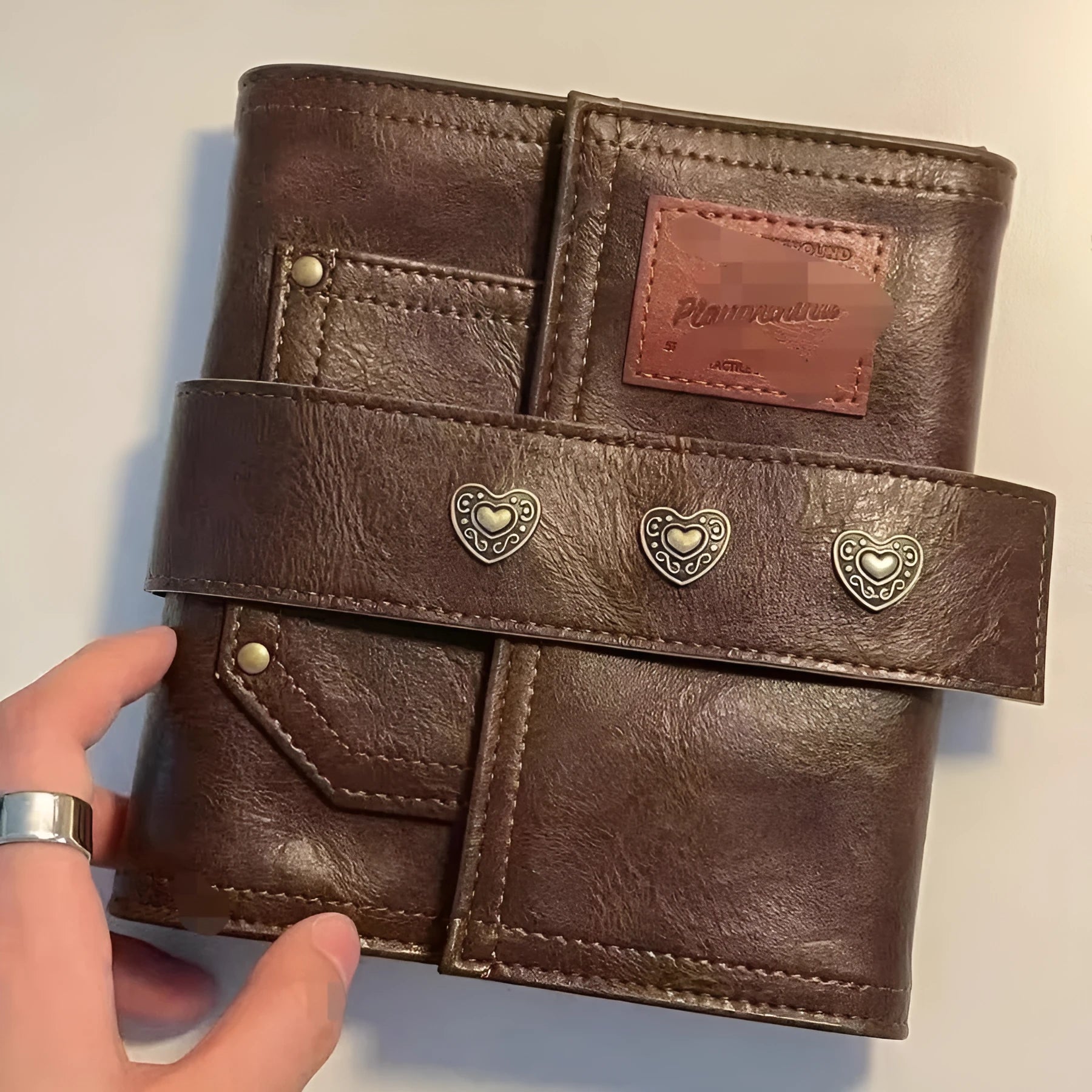 Brown retro leather-look PU cover A7 notebook with loose-leaf binder binding open on a desk.