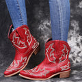 Women's blue cowboy boot with embroidery detail on the side, low wedge heel, and pointed toe.
