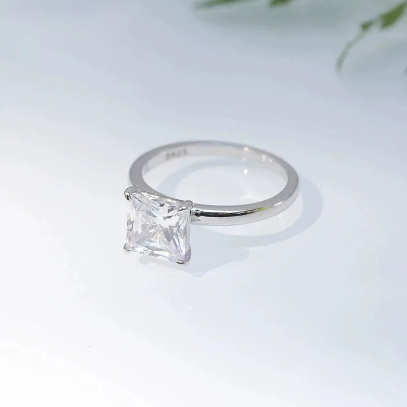 A simple geometric sterling silver ring with a round polished zirconium stone, shown in silver colour.