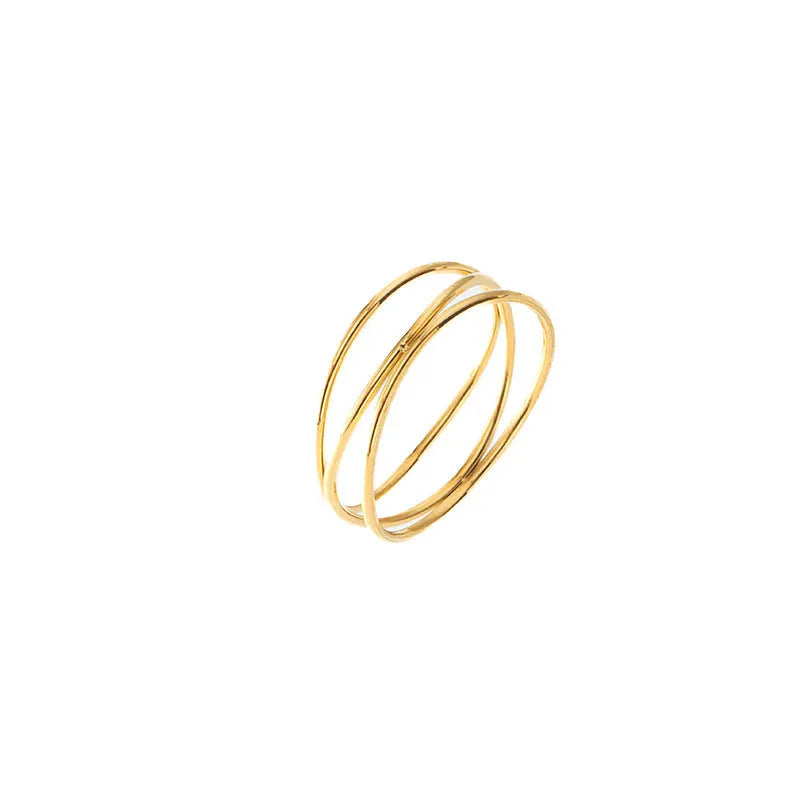Geometric three-layer coil gold ring on a finger, showing titanium steel construction.