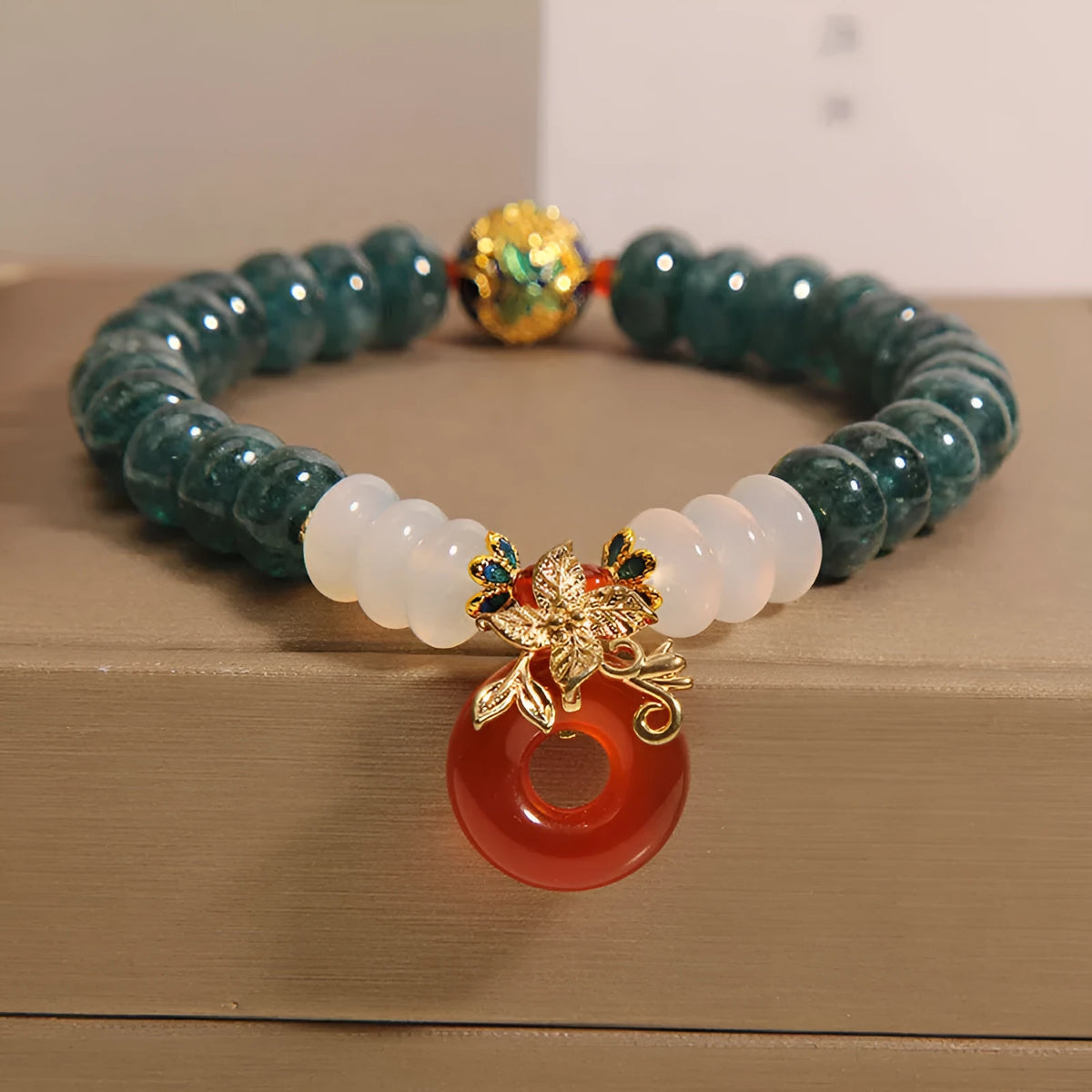 Blue water jade and red agate beaded bracelet with a peace symbol buckle clasp.