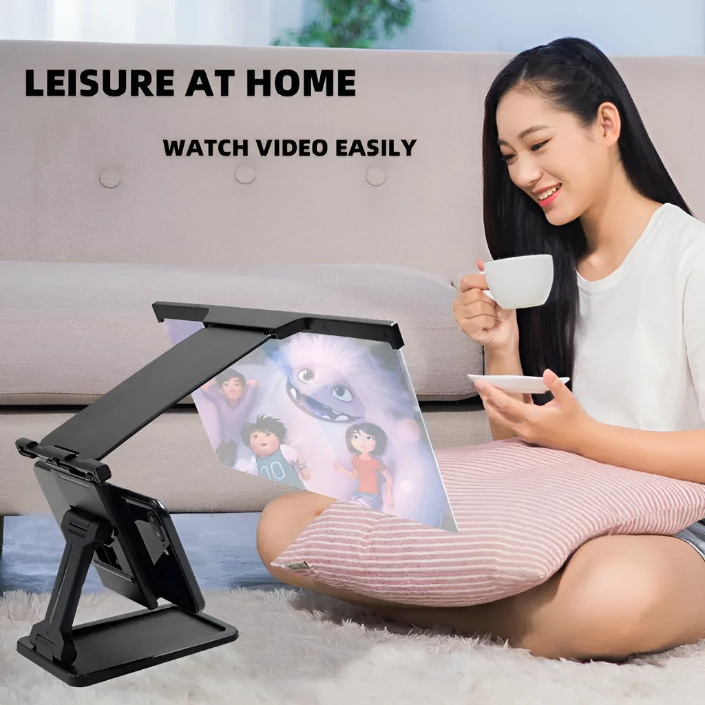 Black folding mobile phone screen amplifier and adjustable holder on a desktop, magnifying a smartphone display.
