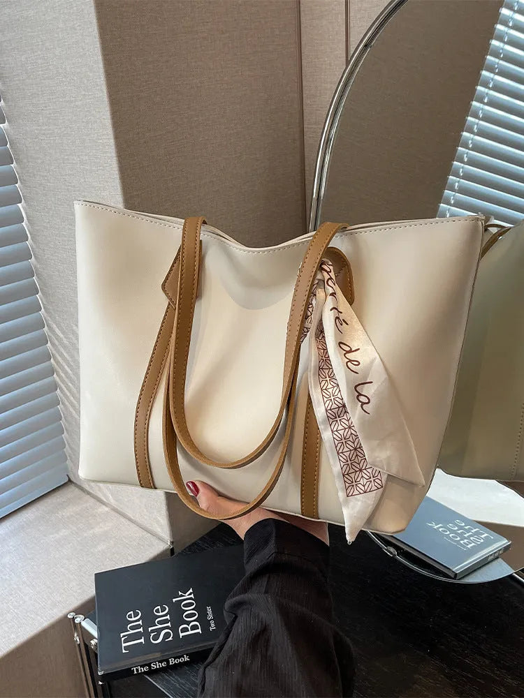 Large soft tote bag with crossbody strap shown in available colour options including black, khaki, white and pink