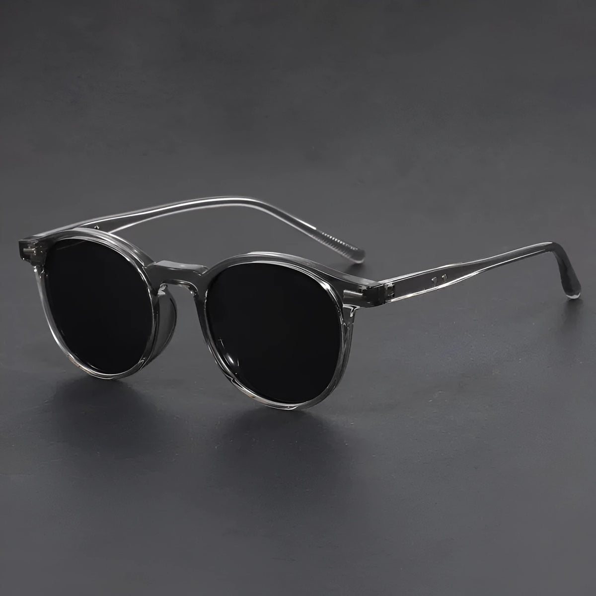 Retro round frame sunglasses with polarised grey lenses on a neutral background.