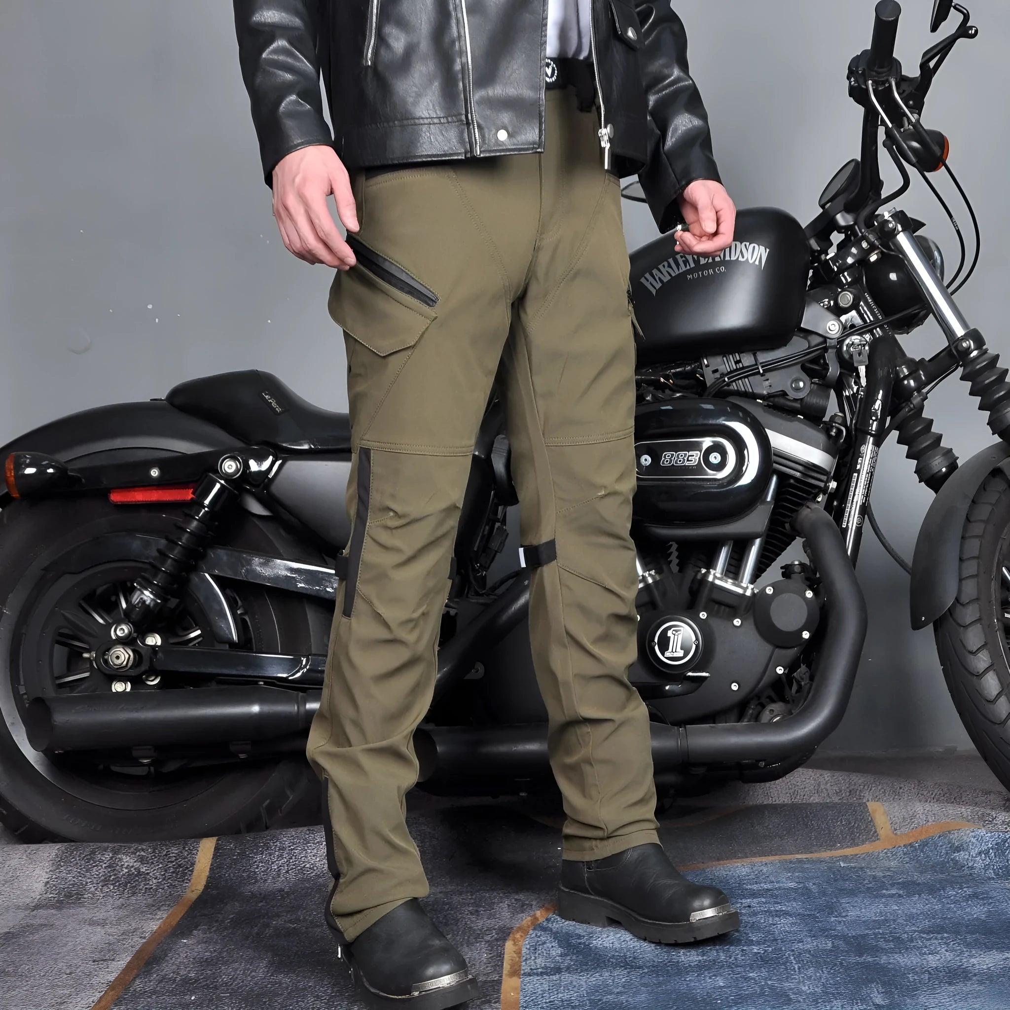 Men's black waterproof motorcycle cycling trousers with belt and protective gear on a hanger.