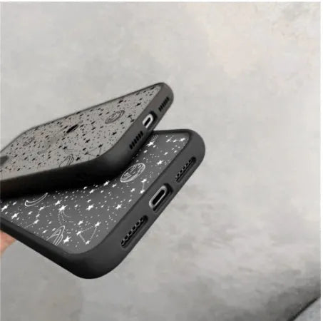 Star universe patterned black iPhone case on a mobile phone, showing raised edges around the screen and camera.