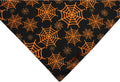 Reversible Halloween dog bandana with pumpkin and spider web patterns in black and orange colours