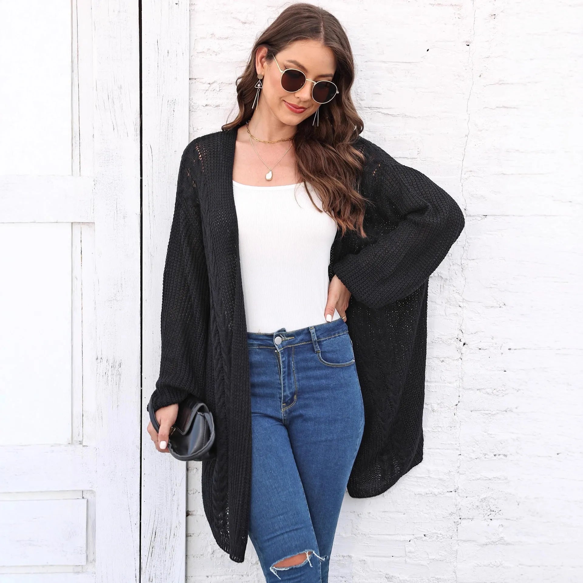 Women's loose fit acrylic sweater coat in a solid colour, shown in a casual setting.