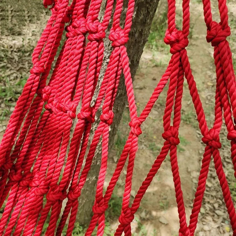 Outdoor nylon rope mesh hammock hanging between trees