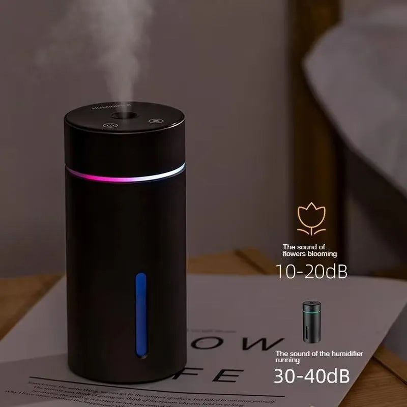 Compact black aluminium car humidifier and essential oil diffuser with USB cable on a desk.