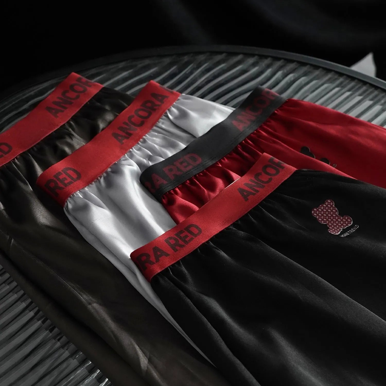 Men's solid colour boxer briefs in black on a mid-waist mannequin, showing knit polyester fabric.