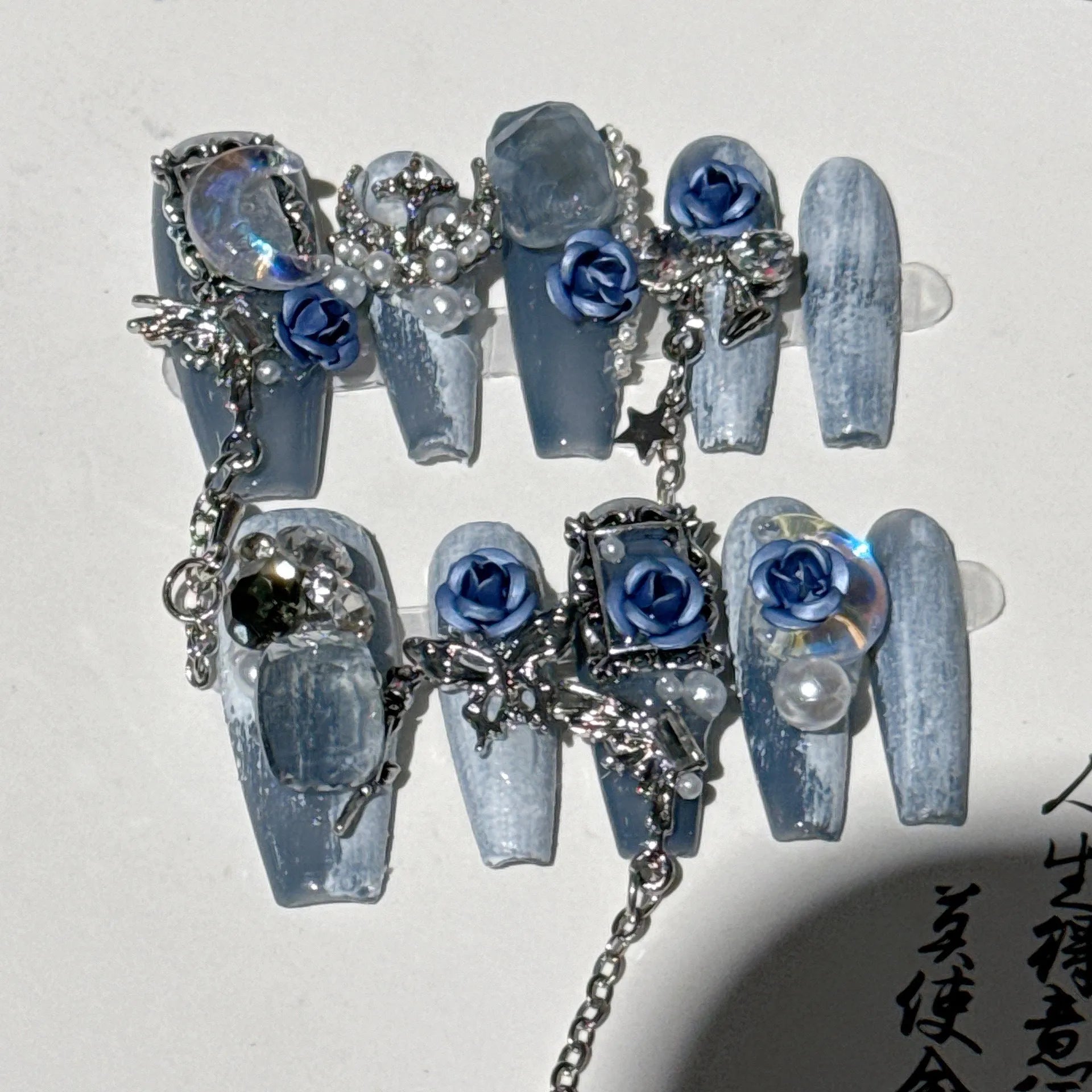 Blue night nail armour with ornate rose and tulip floral patterns in plastic evening manicure set
