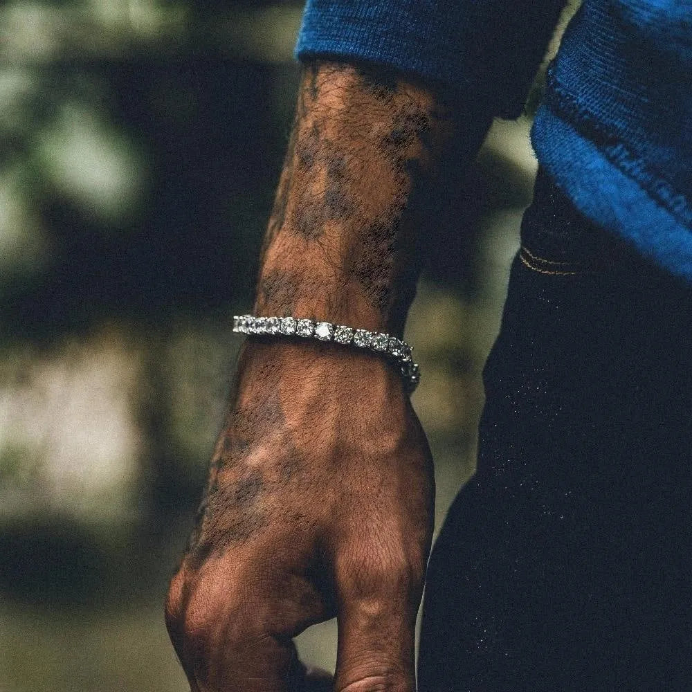 Men's silver geometric link bracelet with a single row of blue rhinestones in an iced-out tennis chain design.