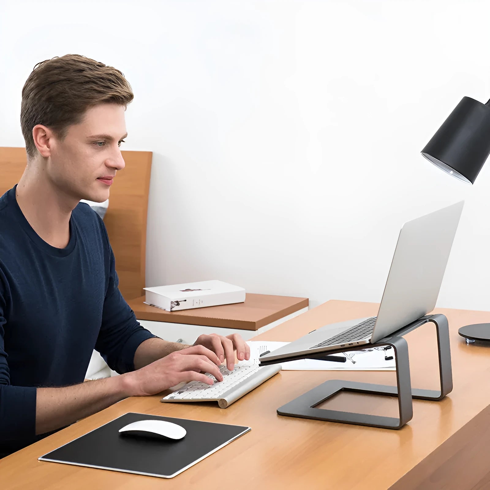 Black aluminium alloy laptop stand with ventilation slots on desktop