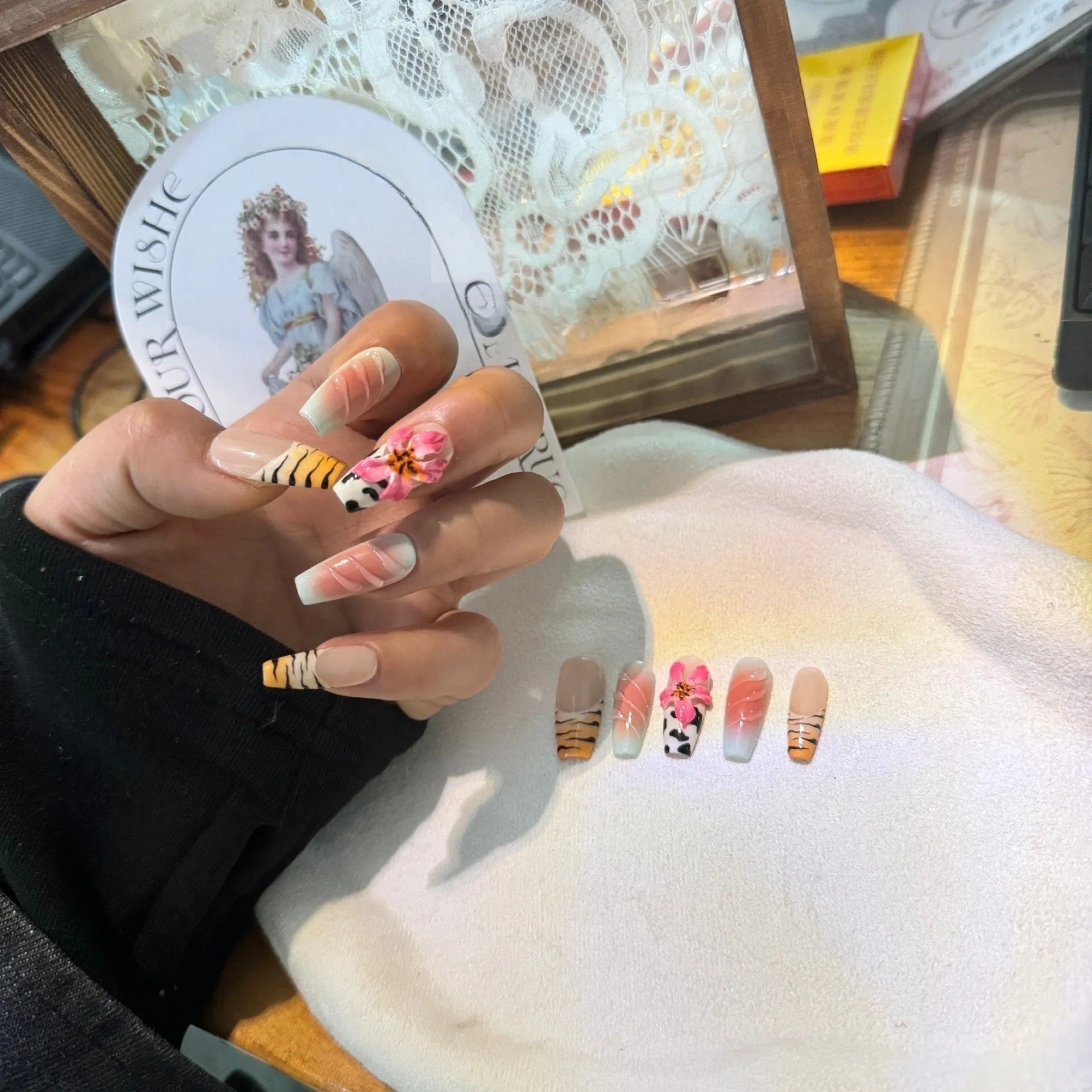 Zebra pattern and Lily hand carved nail art with flower and leopard print designs on a clear background.