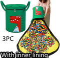 Green felt cube storage bag open showing toys inside, laying flat as play mat