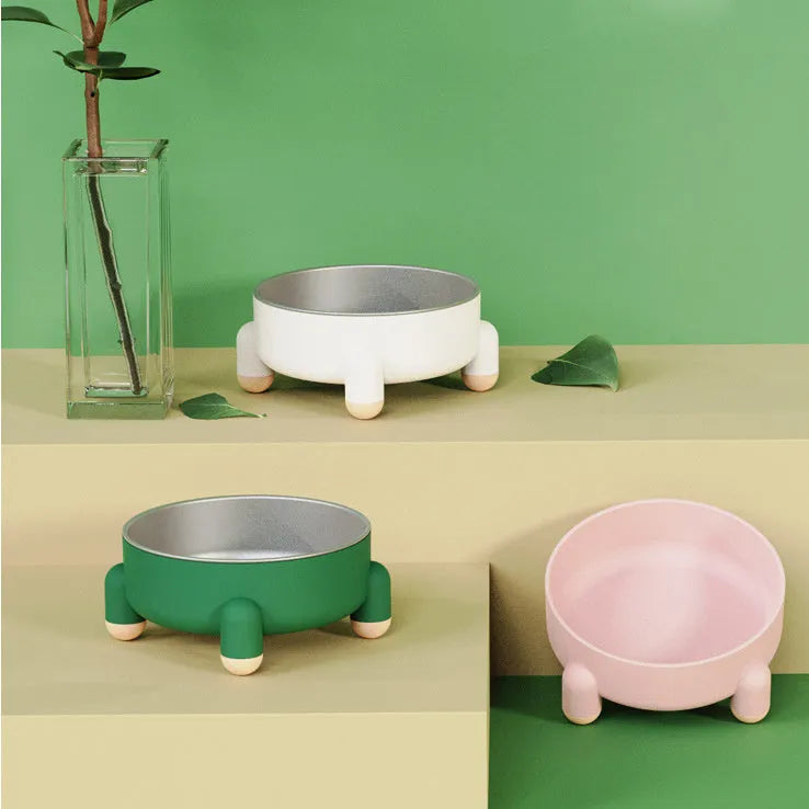 Green stainless steel pet bowl with high foot and non-slip base on a floor
