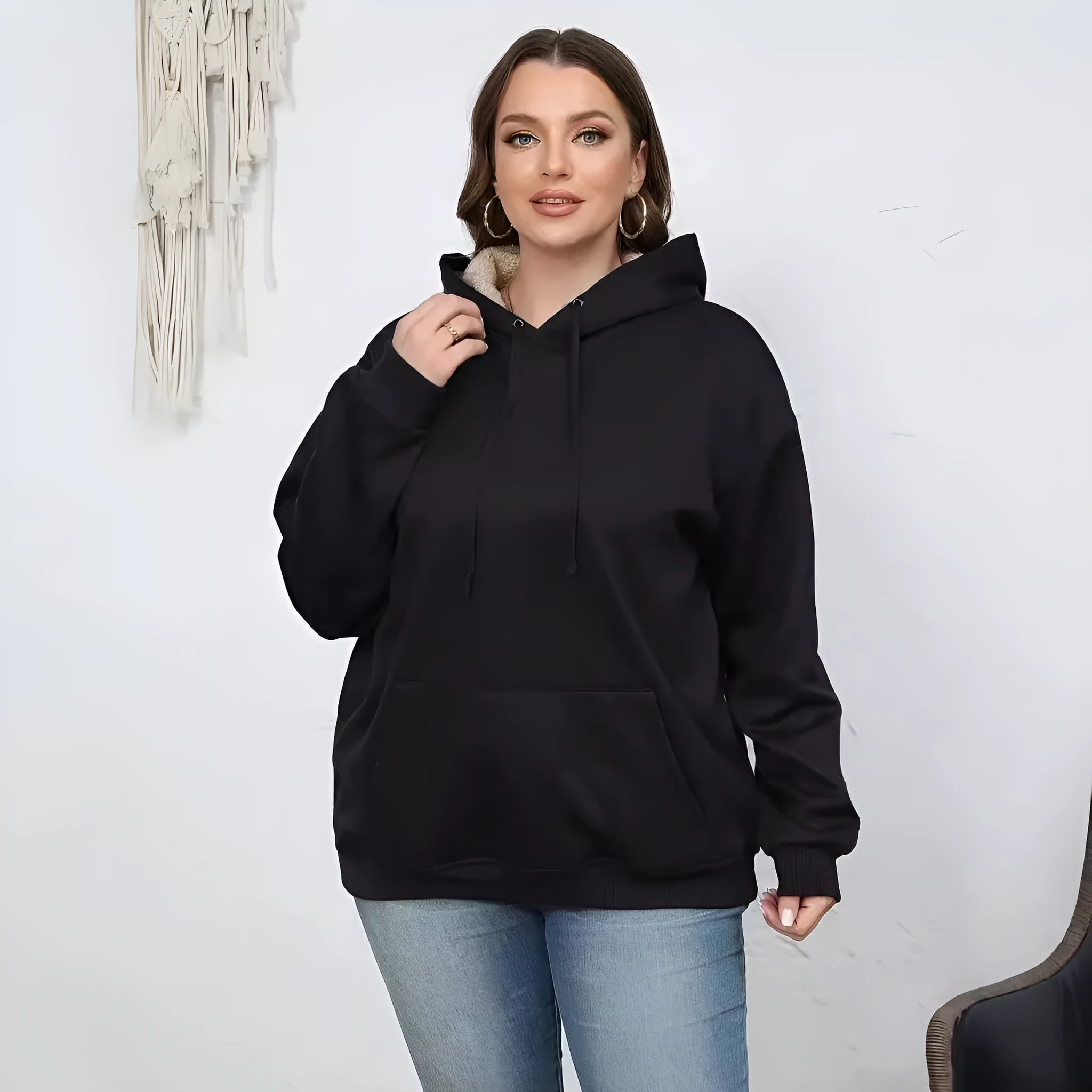 Women's loose black hooded sweater with pockets and a 3D textured pattern, long sleeves.