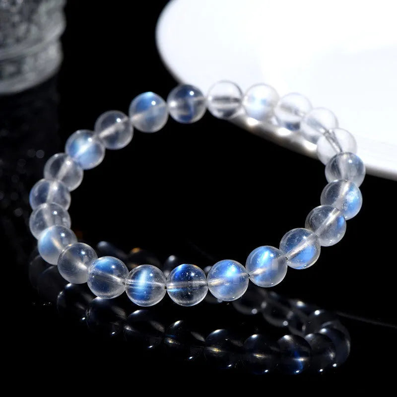 Natural blue moonlight crystal bracelet with smooth beads on a plain background.