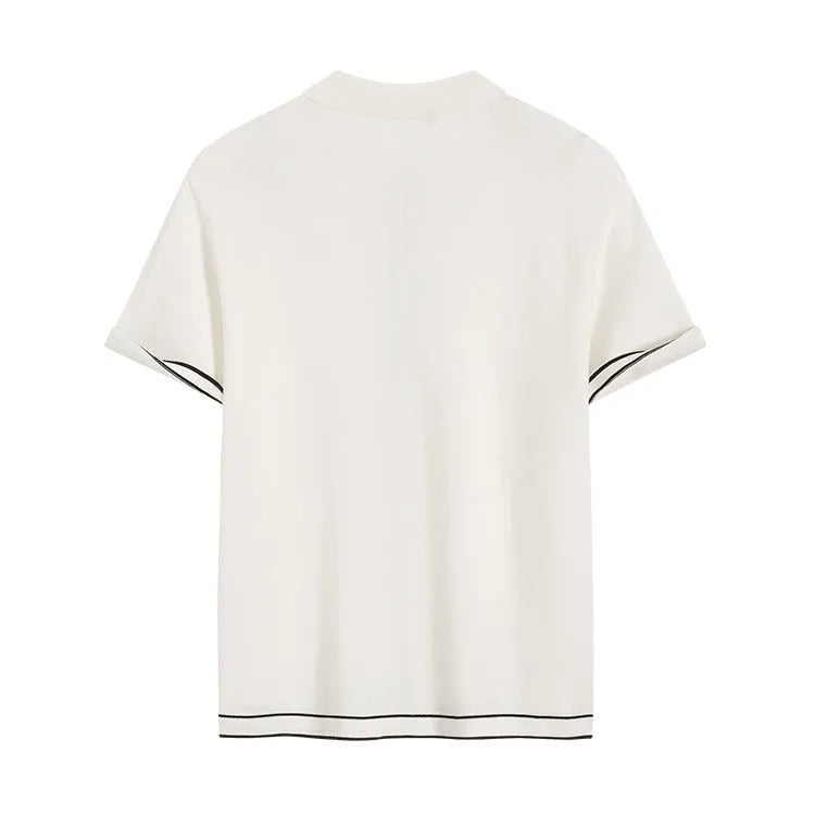 White short sleeve women's cardigan with dark contrast lapels, laid flat.