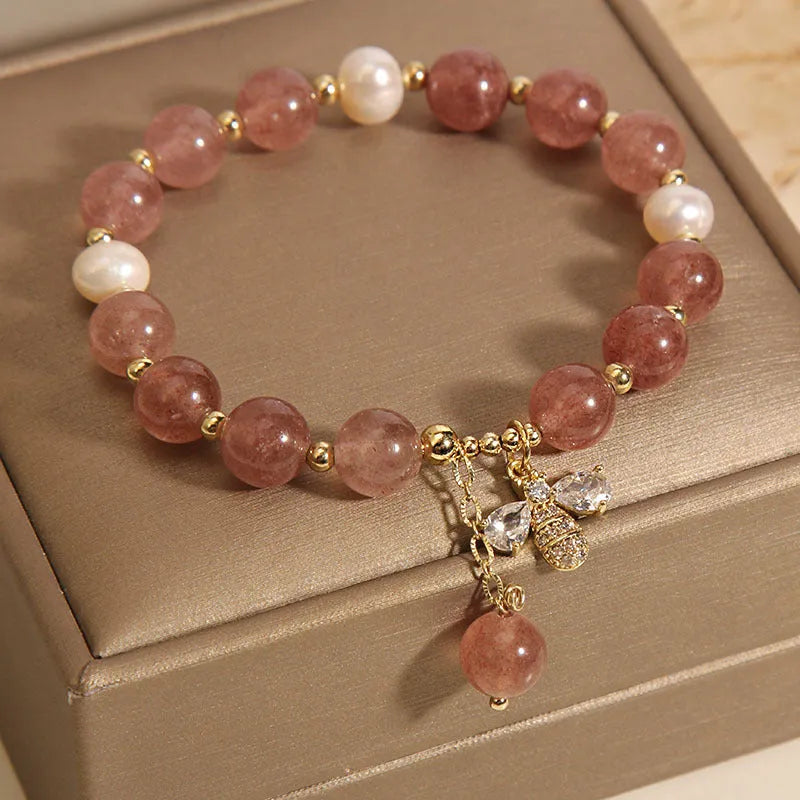 Women's pink strawberry quartz and white freshwater pearl bracelet with zircon accents on wrist