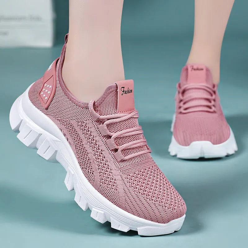 Women's white Flyknit running sneakers with lace-up front and thick PVC sole on a neutral background.