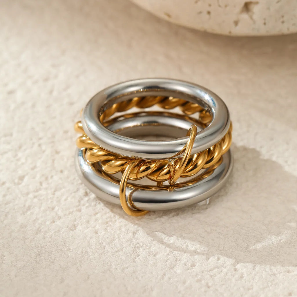 Stacked gold-plated stainless steel rings for women in three colour options, shown as a layered set on a hand.