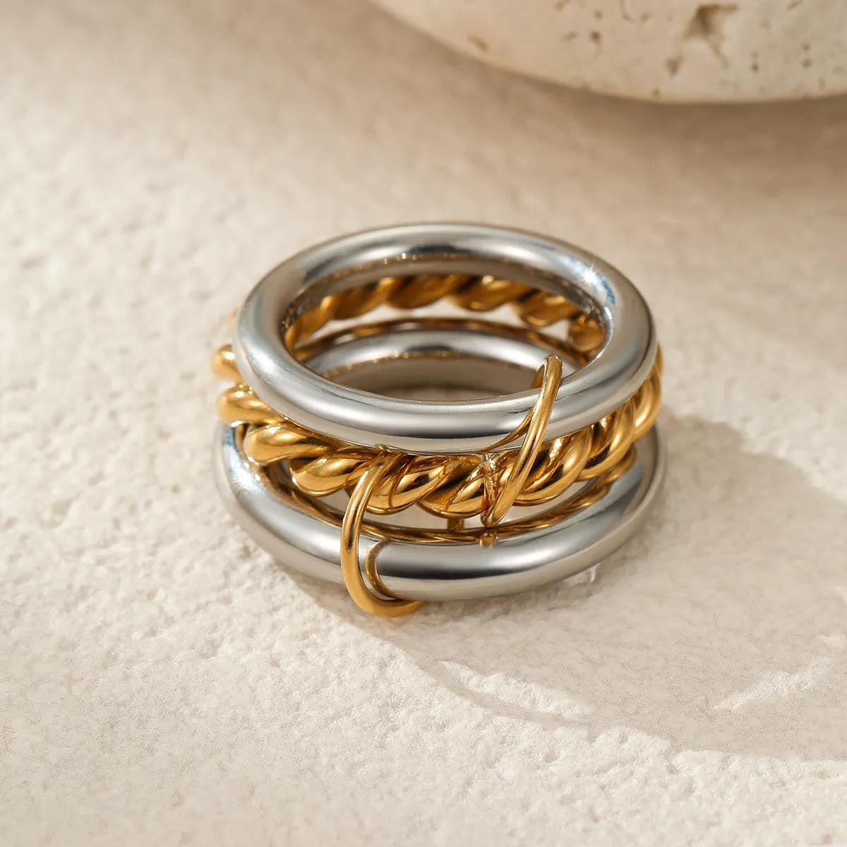 Stacked gold-plated stainless steel rings for women in three colour options, shown as a layered set on a hand.