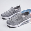 Women's black mesh running shoes with air cushion sole and round toe on a grey background.