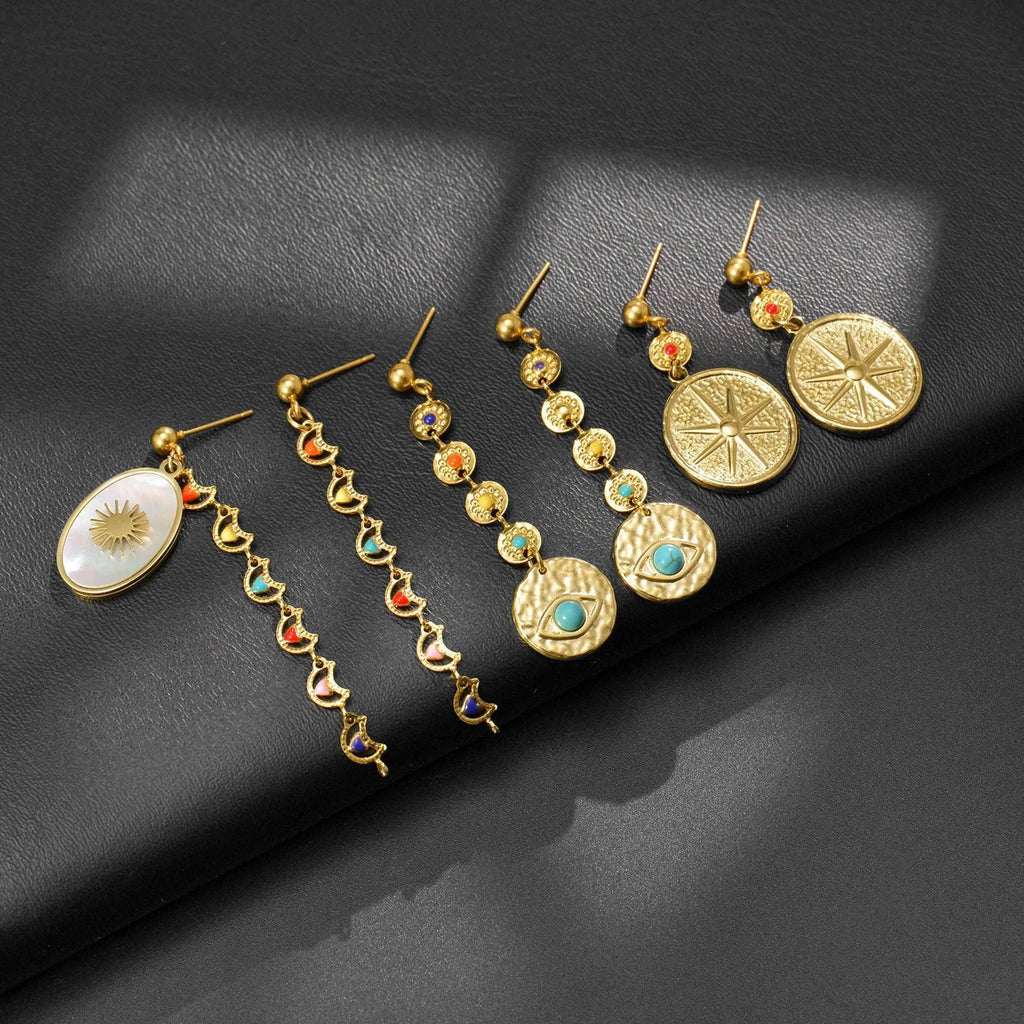 Three pairs of geometric stainless steel drop earrings showing Eight Awn Star, Eye, and Shell Sun designs
