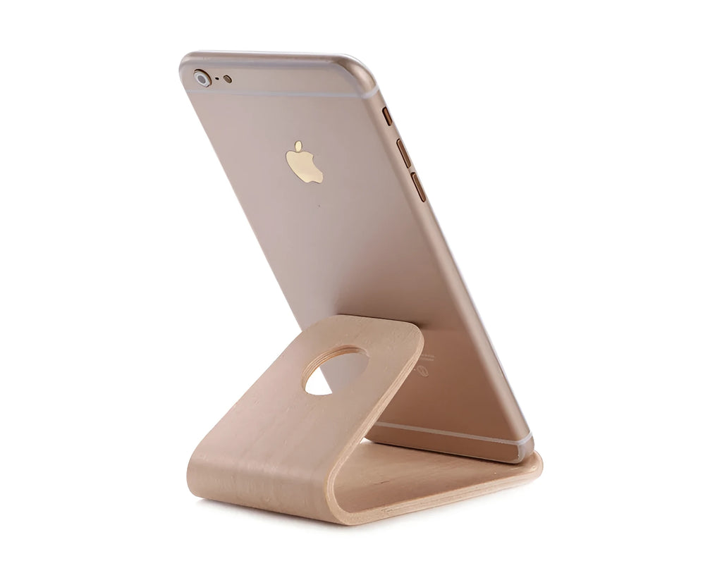 Wooden phone stand in walnut brown and white maple holding an iPhone upright on a desk.