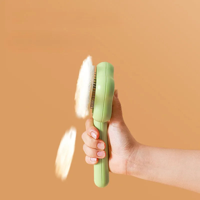 Green self-cleaning magic wand cat comb with stainless steel needle teeth on a white background.