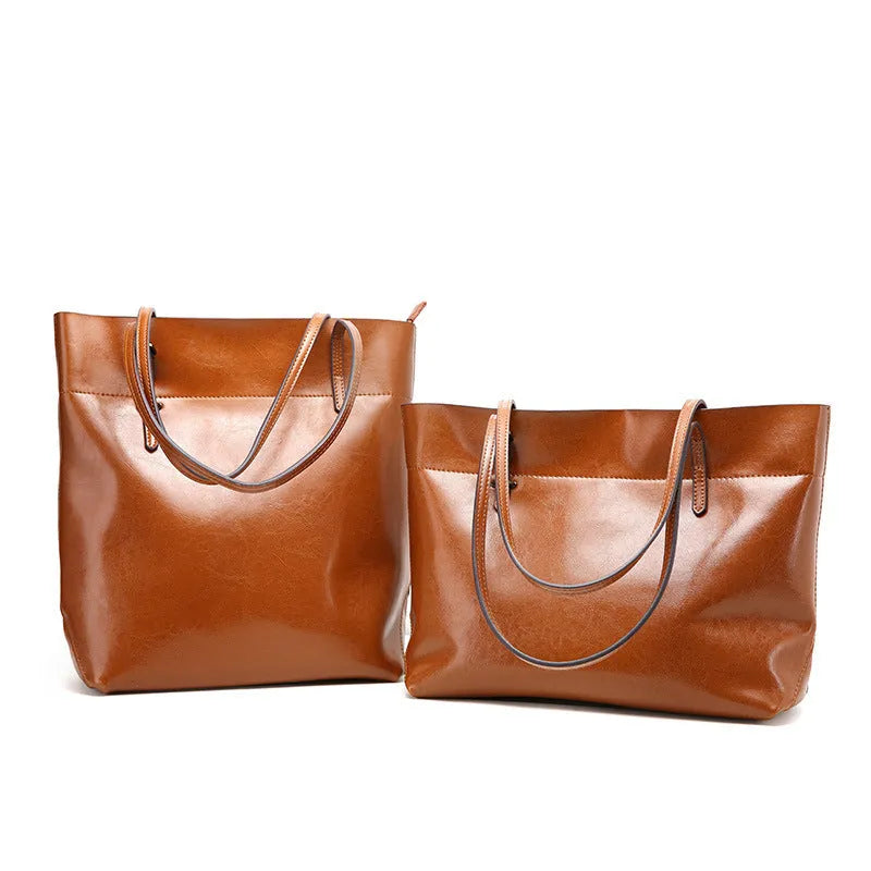 Brown wax cowhide cross-body leather handbag with two compartments showing internal mobile phone pouch.