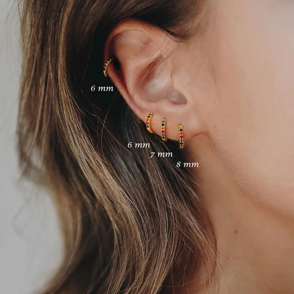 A pair of perforated geometric circle stud earrings with zircon details, shown in gold, rose gold, and silver colour options.