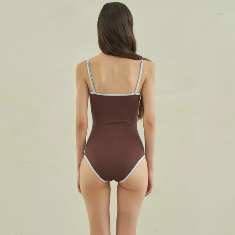 Brown women's one-piece swimsuit with triangle neckline design on mannequin