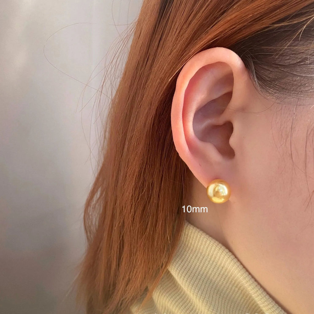 Close-up of retro-style geometric pearl stud earrings in silver, showing eight-awl star detail.