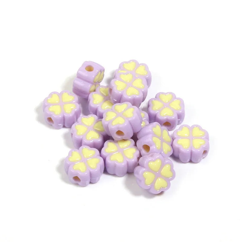 Assortment of frosted acrylic love clover beads in mixed colours on a white background.