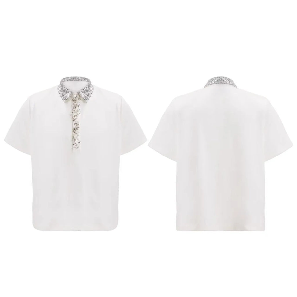 Man wearing a loose fit black polo shirt with a square collar and heavy embroidery sequin detailing on the front