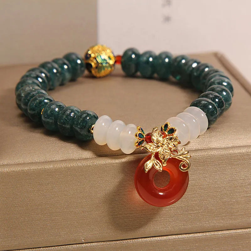 Blue water jade and red agate beaded bracelet with a peace symbol buckle clasp.