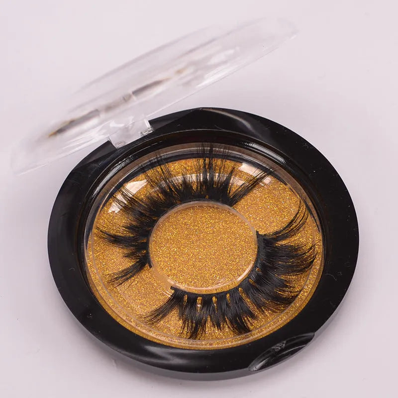 A pair of 5D mink false eyelashes with a hair cap and double-headed brush on a white background.