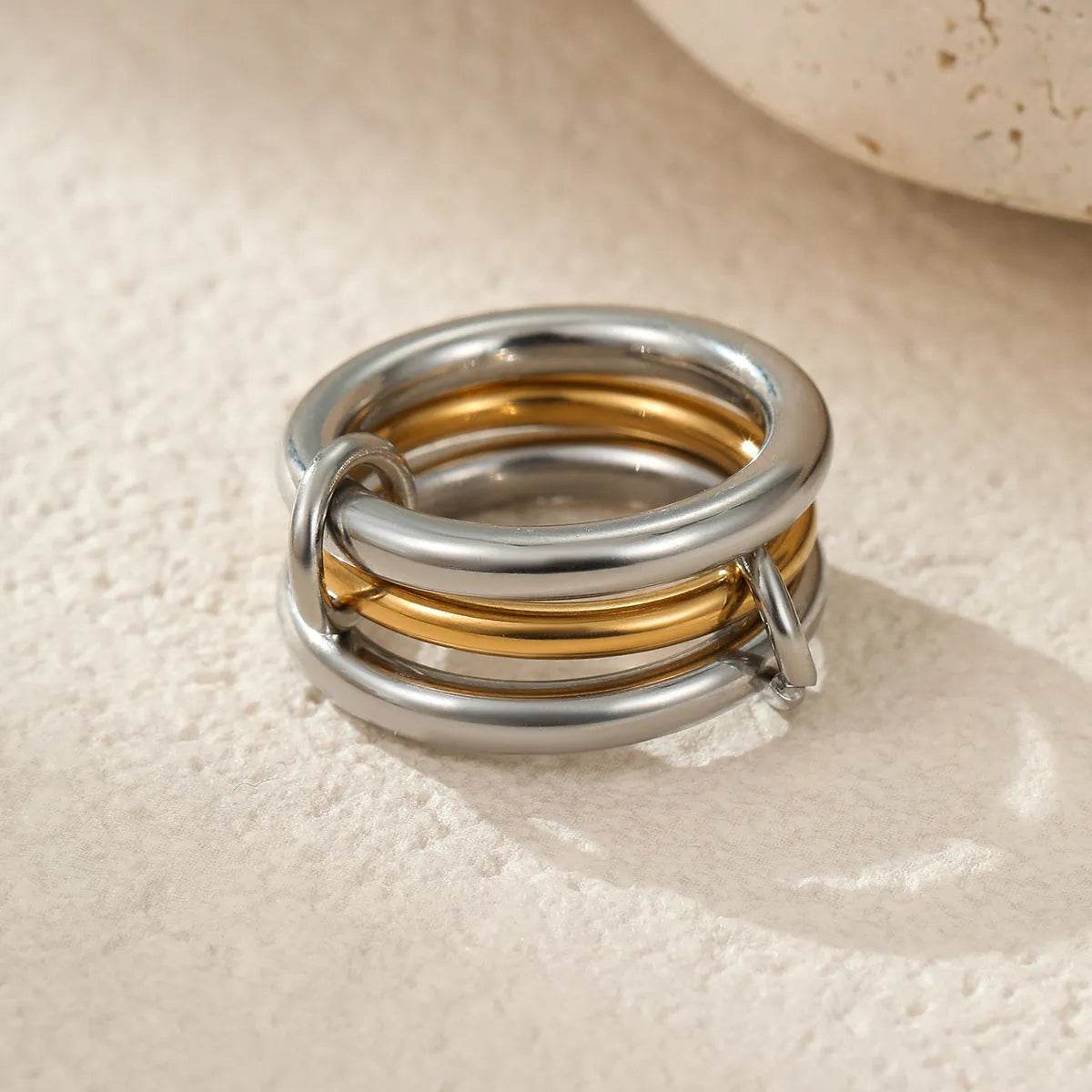 Stacked gold-plated stainless steel rings for women in three colour options, shown as a layered set on a hand.