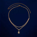 Gold and silver waist chain with a water drop pendant and rhinestone details on a model.