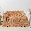 Brown coral fleece sofa throw blanket draped over a grey sofa.