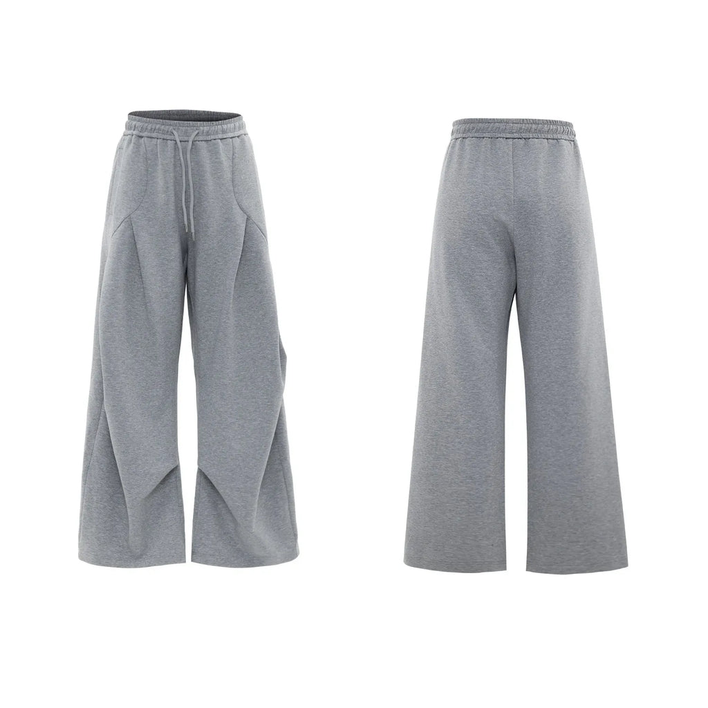 Men's dark grey V-neck cotton sports jacket with padded shoulders and metal detail, worn with matching shorts