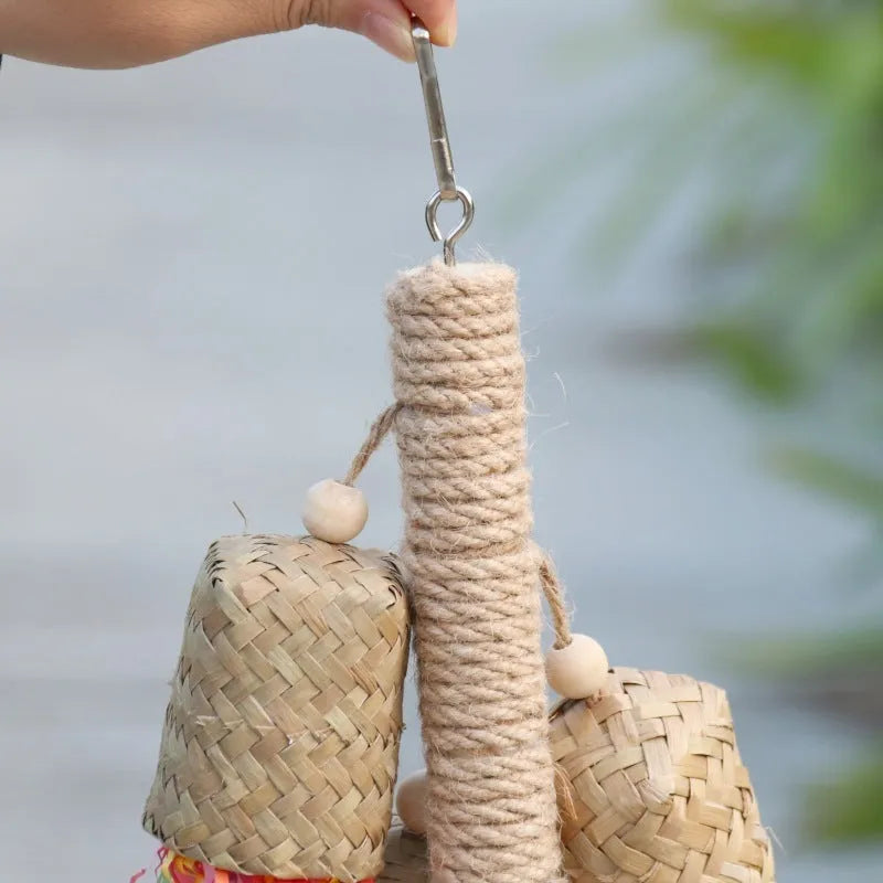 Parrot toy with wood pieces, sisal rope and colourful shredded paper strips hanging for bird enrichment
