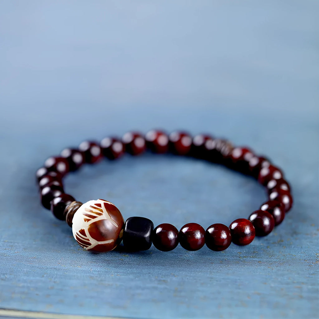Rosewood bracelet with floral beads and circle pendant options on wooden background