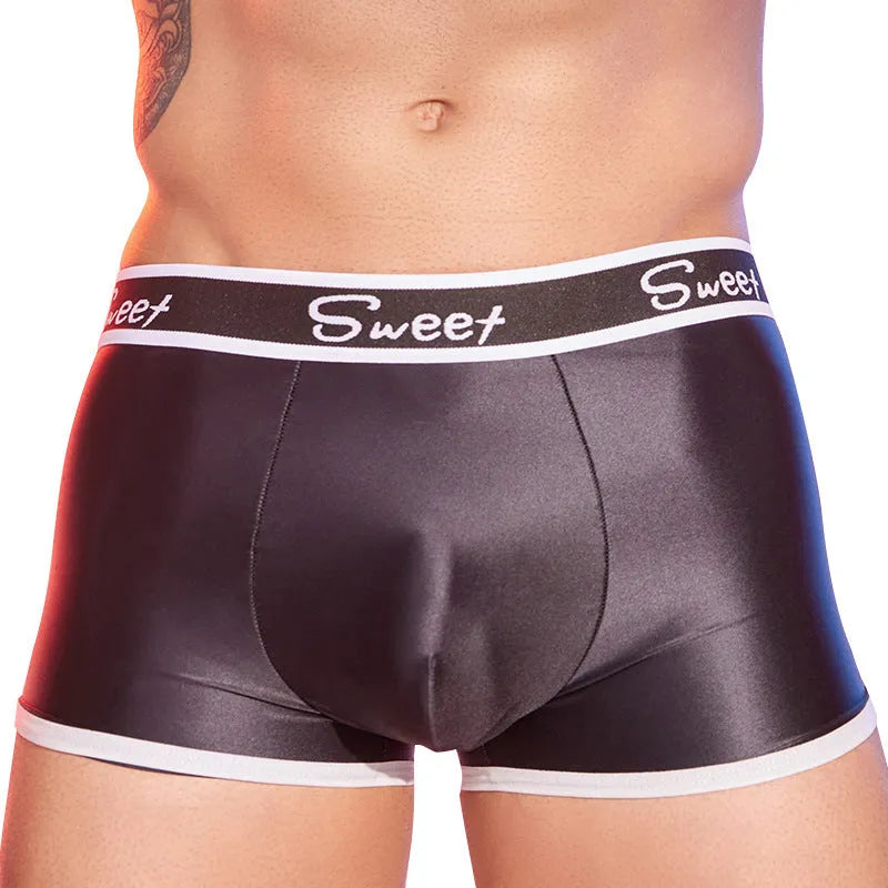 Man's silky shiny boxer shorts in black, white, and sapphire blue colours laid flat.