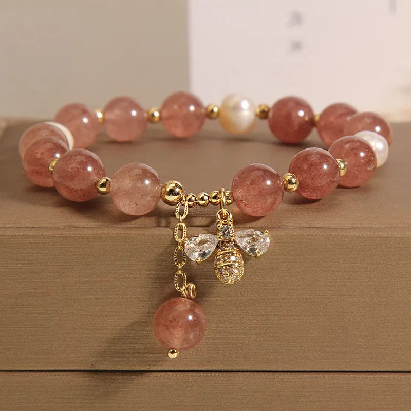 Women's pink strawberry quartz and white freshwater pearl bracelet with zircon accents on wrist