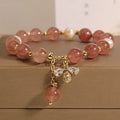 Women's pink strawberry quartz and white freshwater pearl bracelet with zircon accents on wrist