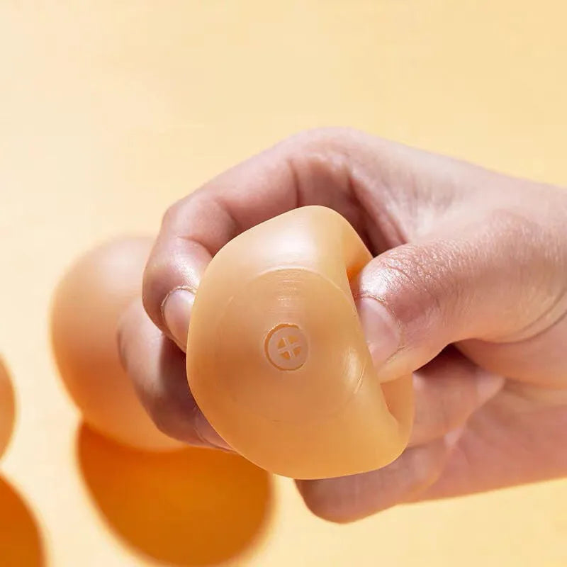 Egg-shaped dog chew toy with textured surfaces for dental cleaning and sound feature